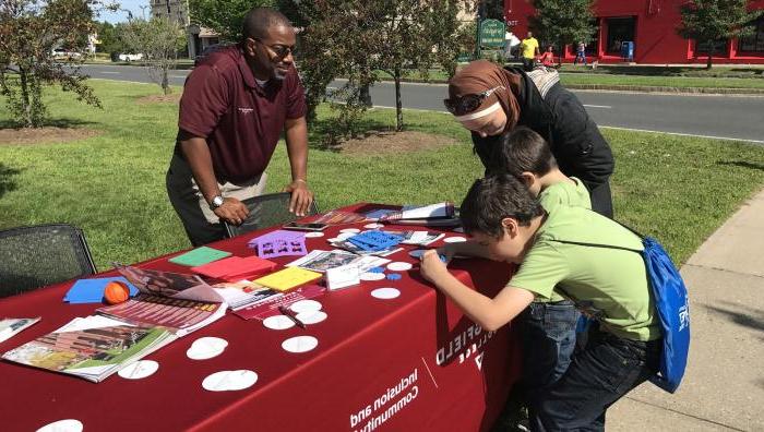 Calvin Hill talks with people in the community as they do crafts. 